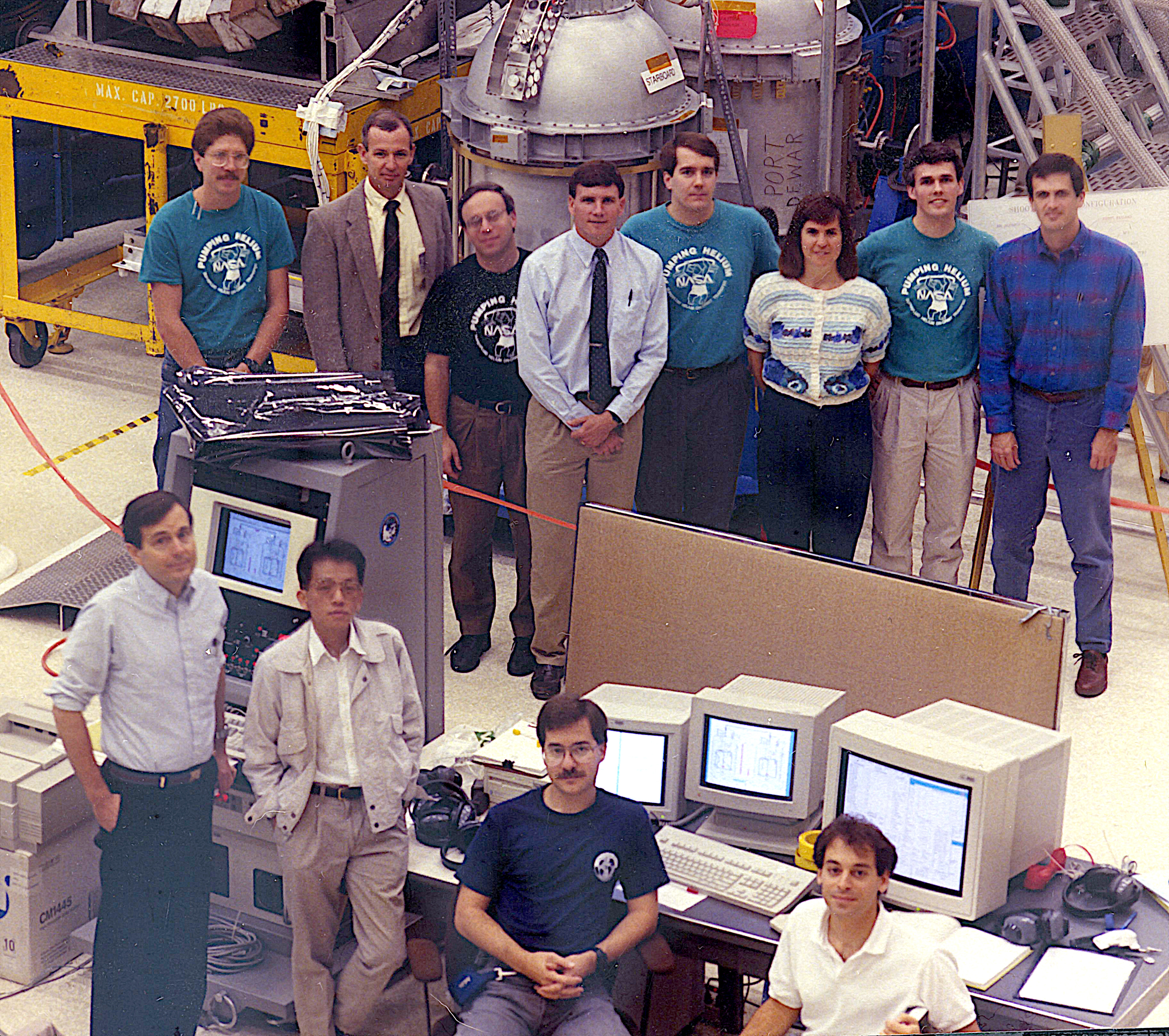 Image: In this image are people well-known to the cryogenics community: Mike DiPirro, Peter Shirron, and Jim Tuttle. If you know them, you should be able to pick them out. (Hint: look at the second row.) Also included are the astronaut mission specialists Janice E. Voss and Peter J. Wisoff, who were tasked with taking care of SHOOT while on orbit. They are third and first from the right in the second row. The two dewars are seen in the background. 